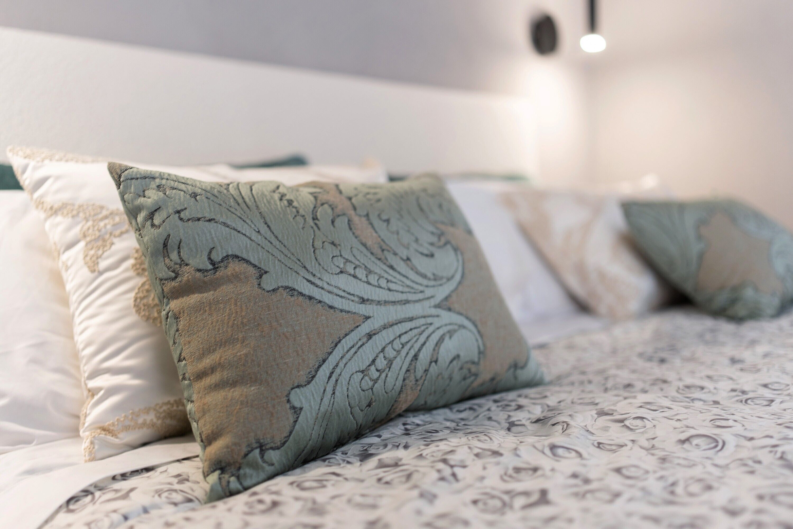 A bed with patterned bedding and decorative pillows.