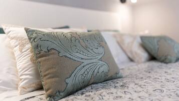A bed with patterned bedding and decorative pillows.