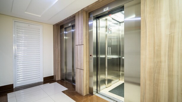 A hallway with two elevators, one marked "Elevator Social" and another with a sign above it.