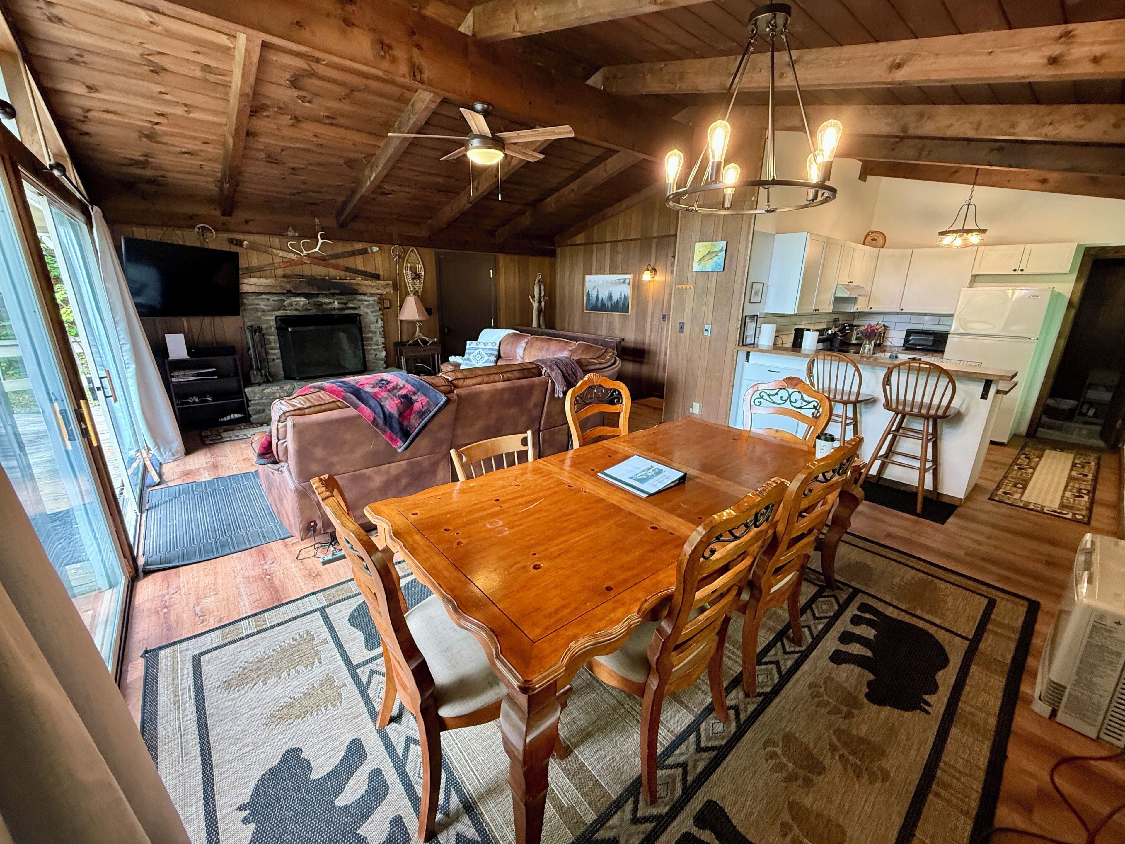A cozy cabin interior with a dining area, kitchen, and living room.