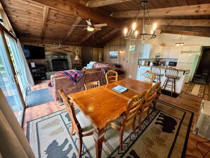 A cozy cabin interior with a dining area, kitchen, and living room.