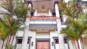 A building with a central entrance, flanked by two columns, and a sign above the door.