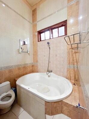 Une salle de bain équipée d’une baignoire, de toilettes et d’un espace douche.