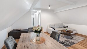 Un loft moderno con comedor, sofá y una pequeña mesa redonda.