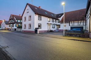 Eine Wohnstraße mit Häusern, einem Auto und einer Straßenlaterne.