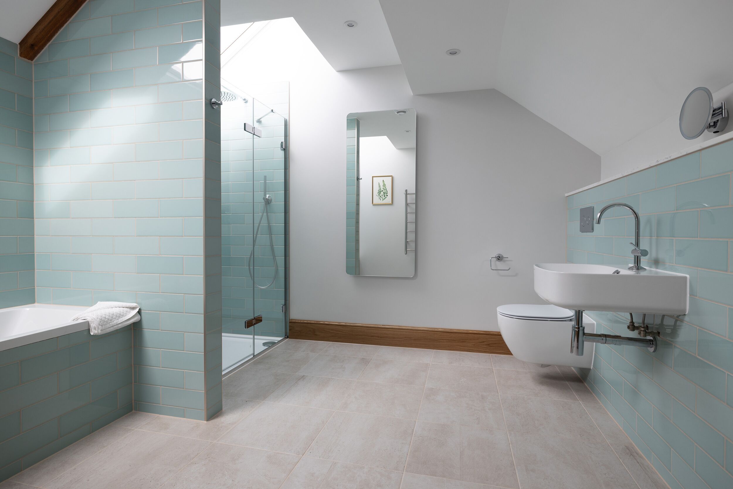 A modern bathroom with a glass shower enclosure, a freestanding bathtub, and a wall-mounted sink.