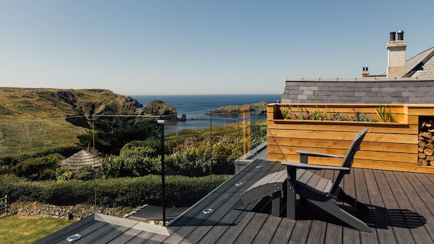 Un ponte di legno con vista sul mare e sulle colline.