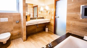 Ein modernes Badezimmer mit Badewanne, Waschbecken inklusive Spiegel und Toilette.