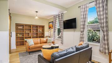 TV connectée, cheminée, table de tennis de table, livres