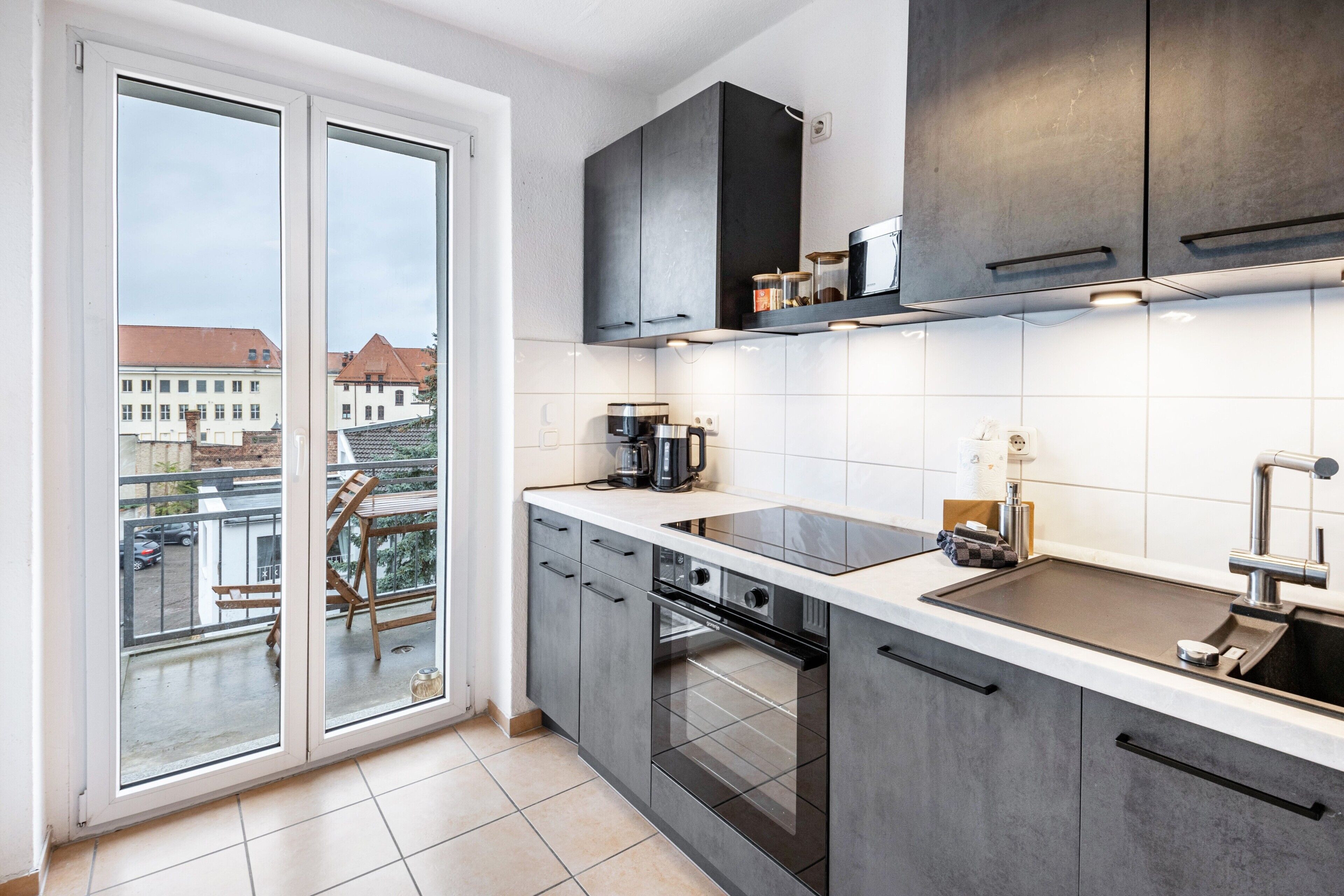 Una cocina moderna con un ventanal grande, horno empotrado y vistas a la ciudad.