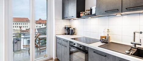 Una cocina moderna con un ventanal grande, horno empotrado y vistas a la ciudad.