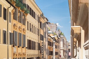 A narrow street lined with historic buildings featuring ornate facades and shuttered windows. - Rental in Rome Frattina Atmosphere Apartment (Rome)