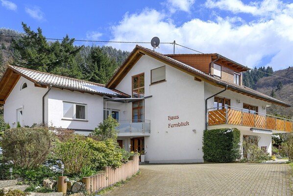 A two-story building with a balcony and a satellite dish.