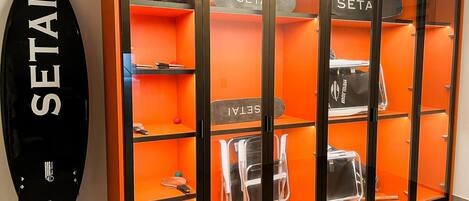 A glass display case with the word 'SETAI' on the door, containing various items like bags and a suitcase.