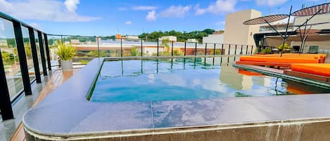 Una piscina en la azotea con vistas despejadas a los edificios y al cielo circundantes.