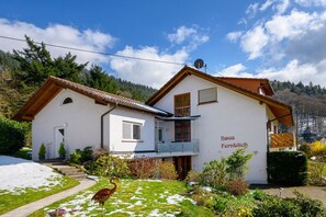 A two-story house with a white exterior, a balcony, and a sign reading 'Haus Fernblick.' - Holiday Home 'Häusle' with Panoramic View, Private Terrace, Covered Balcony & Wi-Fi (Badenweiler)
