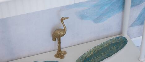 A white bench with a decorative bird and two leaves.