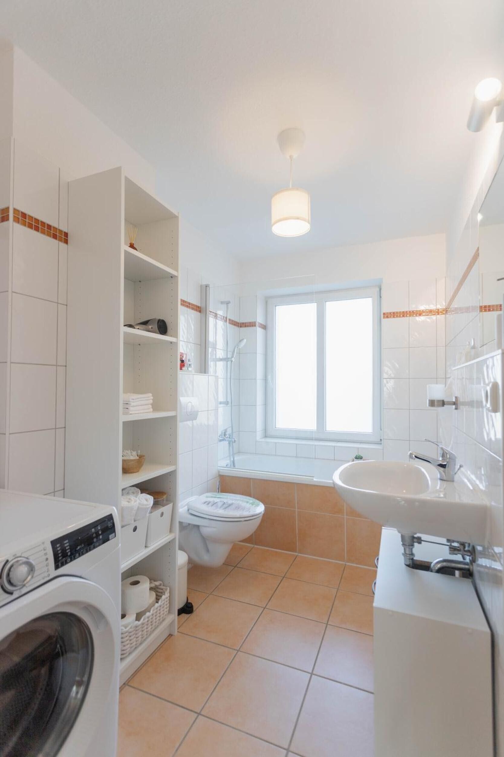 Un baño moderno con lavadora, inodoro y lavamanos.
