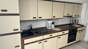Een koelkast, een oven, een kookplaat, een koffiezetapparaat/waterkoker
