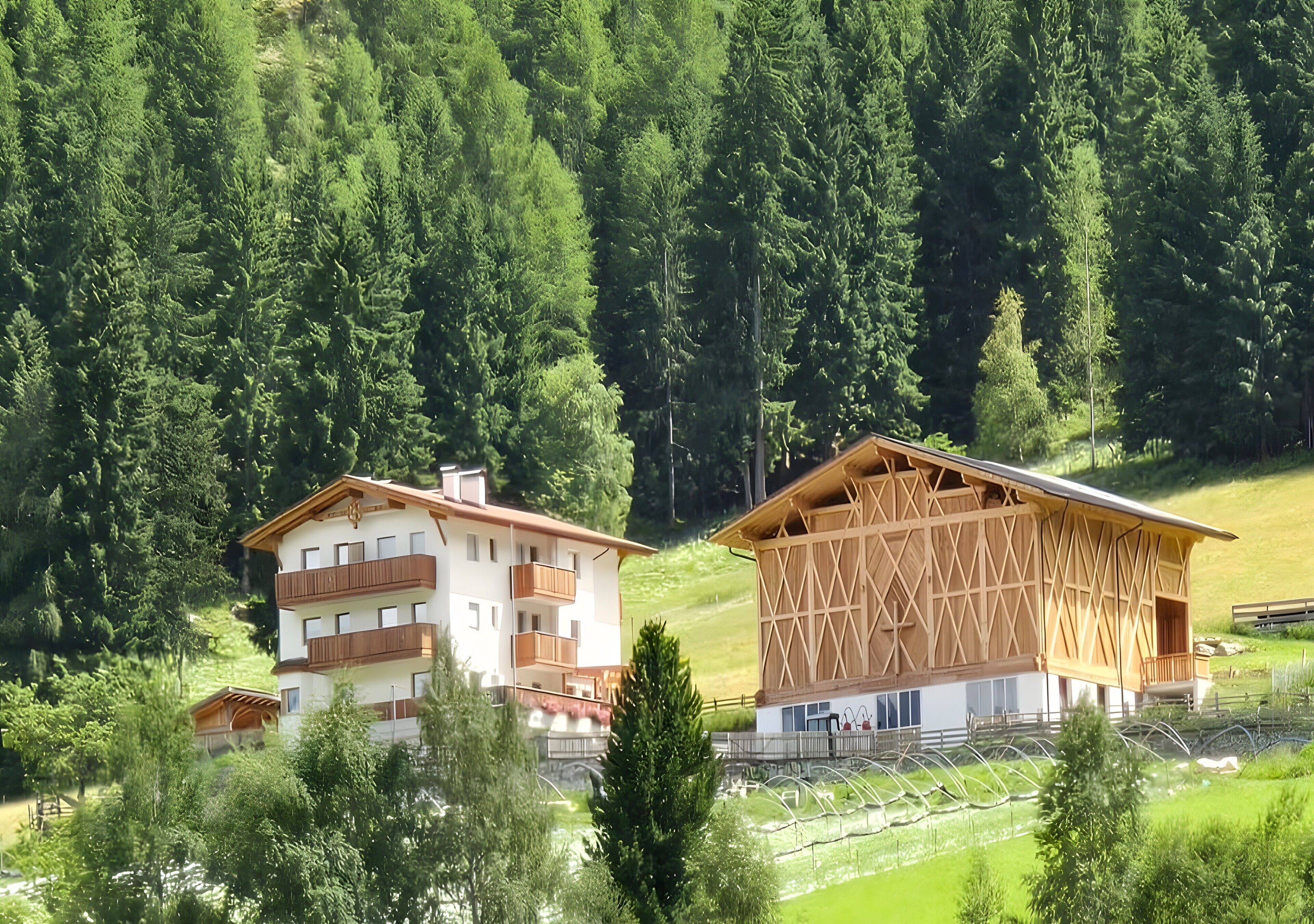 Eine Berglodge mit Holzbalkonagebäude, mehreren Balkonen und Blick auf einen bewaldeten Berghang.
