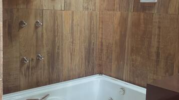 Chuveiro, banheira de hidromassagem, bidê, toalhas de banho