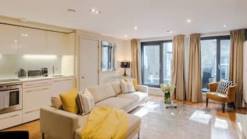 Appartamento Deluxe, balcone, vista città | Area soggiorno | Smart TV 42 pollici con canali digitali