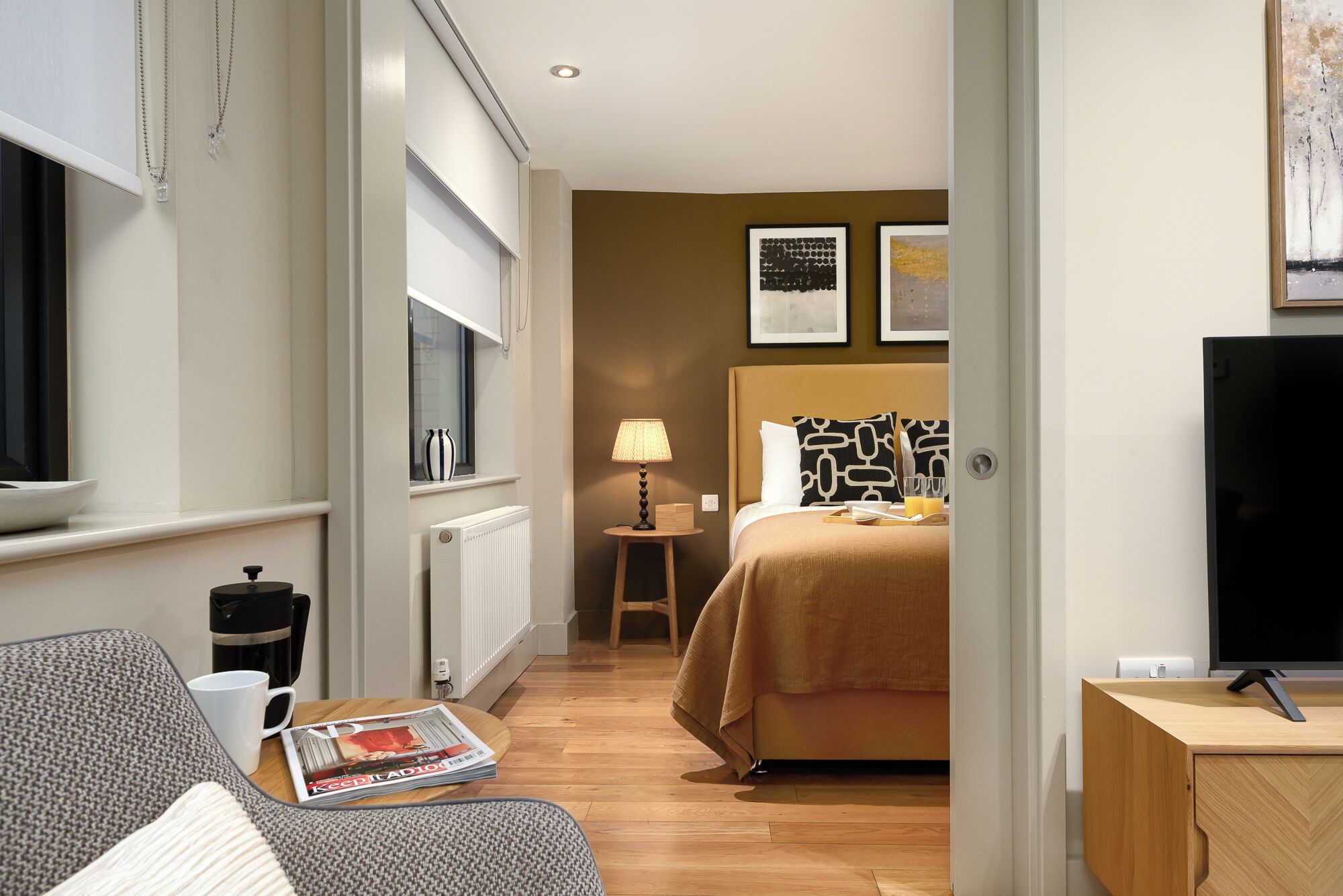 Une chambre d’hôtel moderne équipée d’un lit, d’une table de chevet, d’une lampe et d’un téléviseur.