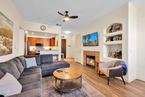 A modern living room with a sectional sofa, a round coffee table, and a fireplace.