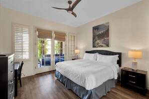 A bedroom with a bed, two bedside tables, a ceiling fan, and a painting on the wall. - Heritage Hideaway A | 1BR Legacy Villa (La Quinta)