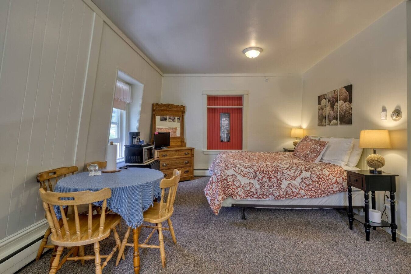 Une chambre à coucher comprenant un lit, une table de chevet, une lampe et un bureau avec une chaise.