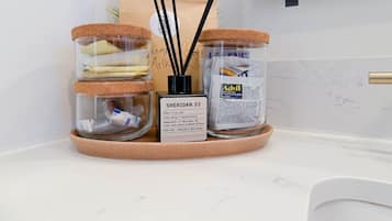 Eine Küchenarbeitsplatte mit drei Gläsern mit Korkdeckeln, einer Advil-Flasche und einer Raumdüsensprühflasche.