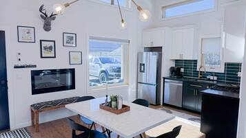 A modern kitchen with white cabinets, a stainless steel refrigerator, and a built-in oven.