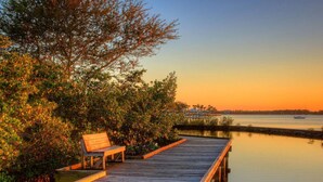 A wooden dock with a bench, surrounded by dense foliage and leading to calm water. - 4br/2ba Zen Garden mins to adventures (Stuart)