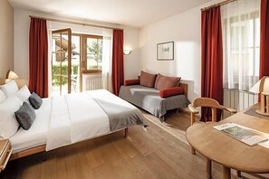 Une chambre d’hôtel équipée d’un lit, d’un canapé, d’une table à manger et offrant une vue sur l’extérieur.