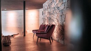 Une chambre moderne avec un mur en pierre, un plancher en bois et un fauteuil en cuir.