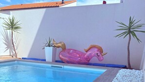 A swimming pool with a wooden deck, white pebbles, and two palm trees. - Beautiful room in new villa with swimming pool (Perpignan)