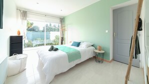 Ein Schlafzimmer mit Bett, Fenster, Tür und einem kleinen Tisch.