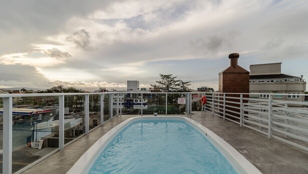 Une piscine intérieure offrant une vue sur le paysage urbain et un ciel nuageux.