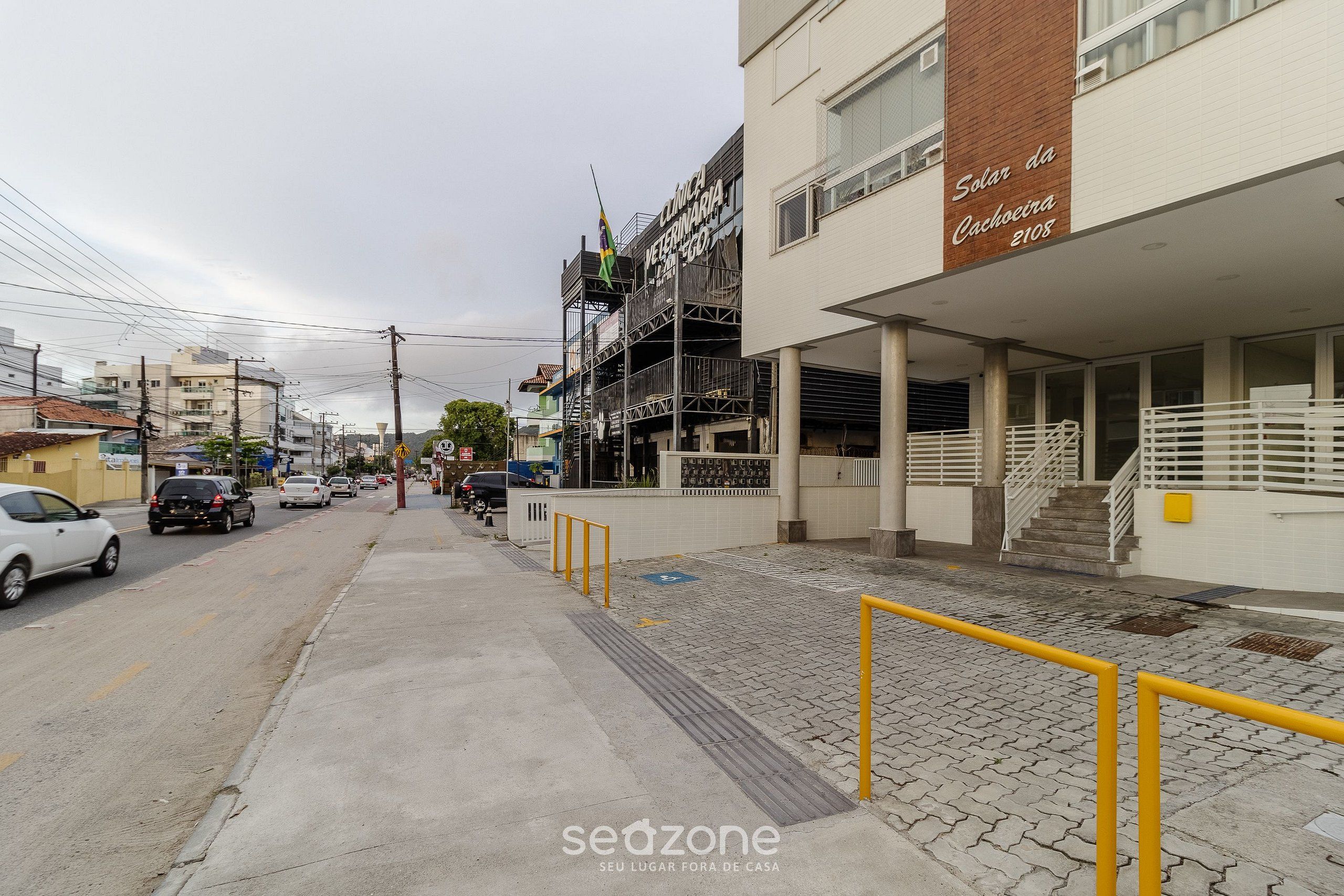 Egy utcai kép, amelyen egy állatorvosi rendelő, egy „Solar da Cachoeira 2108” feliratú épület, valamint egy burkolt járdaszakasz látható, melyet sárga korlát szegélyez.