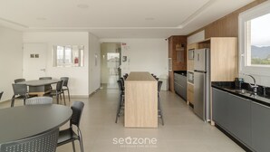 Une cuisine moderne avec un îlot central, des chaises noires et une table à manger.