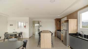 Una cocina moderna con una isla central, sillas negras y una mesa de comedor.