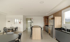 Una cocina moderna con una isla central, sillas negras y una mesa de comedor.