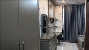 Ein Schlafzimmer mit Kleiderschrank, Schminktisch, Spiegel, Stuhl und Bett.