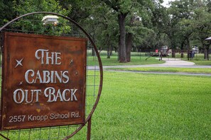 A sign for 'The Cabins Out Back' at 2557 Knopp School Rd.