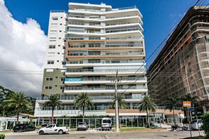 A multi-story building with a modern architectural design, featuring balconies and large windows. - Charming apt w/ Balcony 150m From the Beach Abc0403 (Itajai)