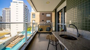 A balcony with a pool, a sofa, a bar area, and a view of the cityscape. - Charming apt w/ Balcony 150m From the Beach Abc0403 (Itajai)