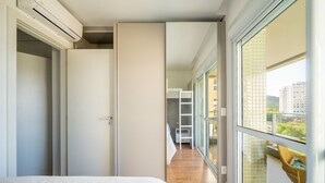 A modern hotel room with a large bed, a sliding door leading to a balcony, and a view of the cityscape. - Charming apt w/ Balcony 150m From the Beach Abc0403 (Itajai)