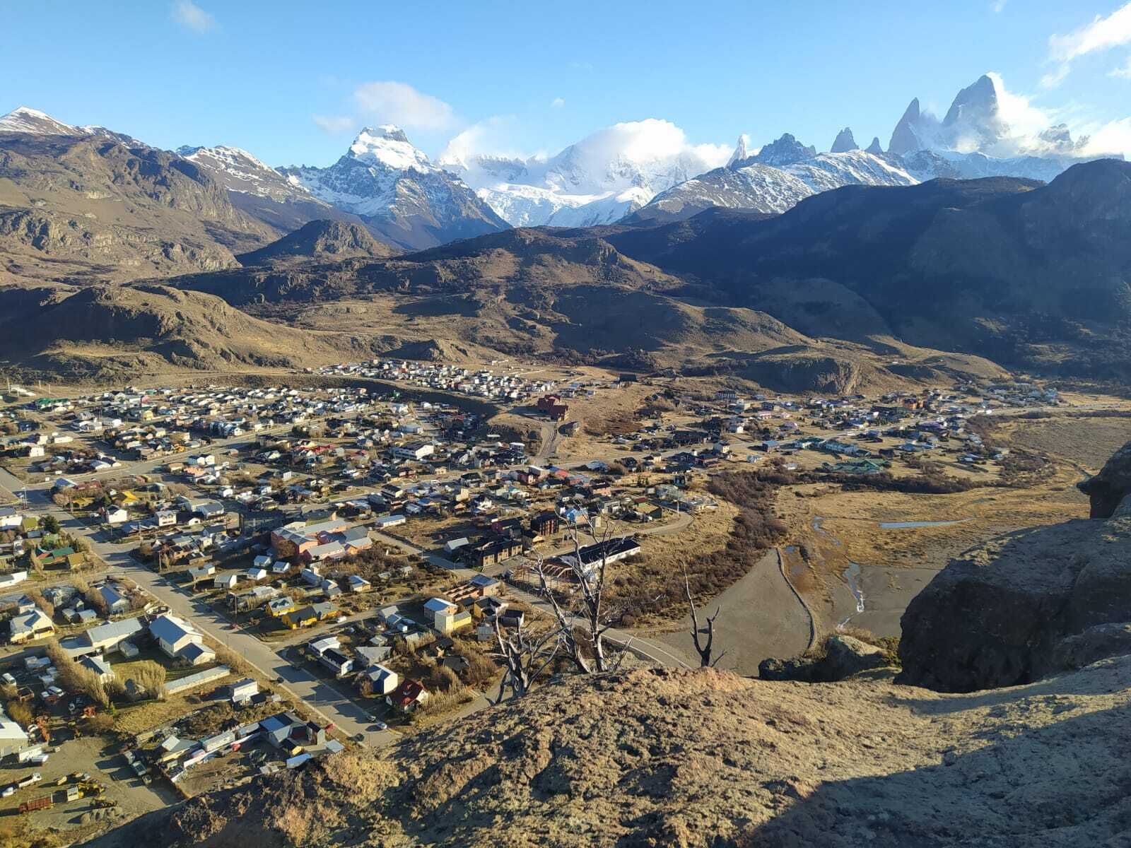A town nestled in a valley with a backdrop of snow-capped mountains.