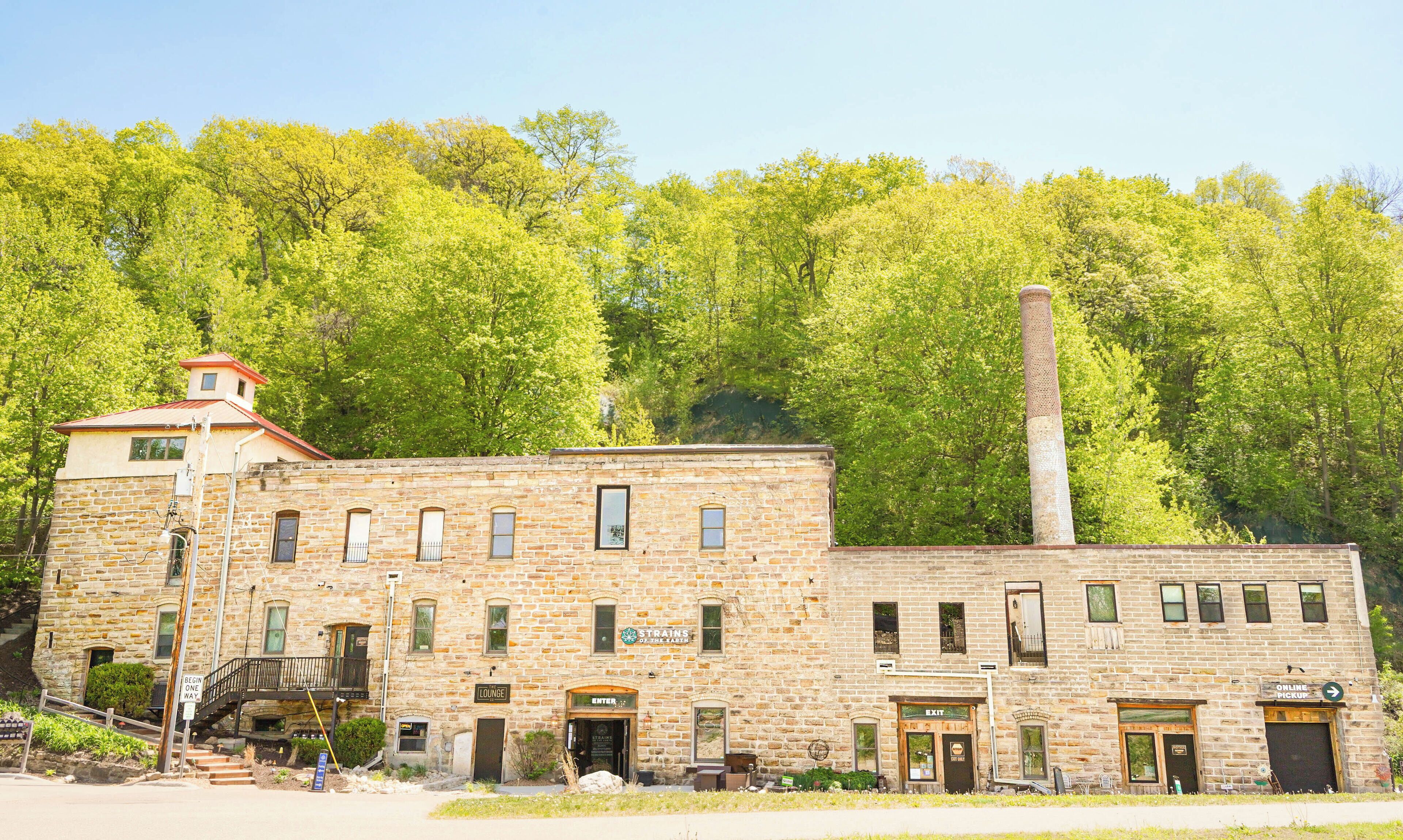 A stone building with a chimney, labeled 'Strains of the Tar Barrel,' and a sign for 'Lounge.'