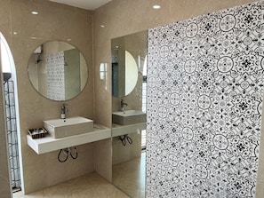A modern bathroom with a large mirror, a white sink, and a tiled shower area. - Hotel River 2 Hai Phong (Hai Phong)